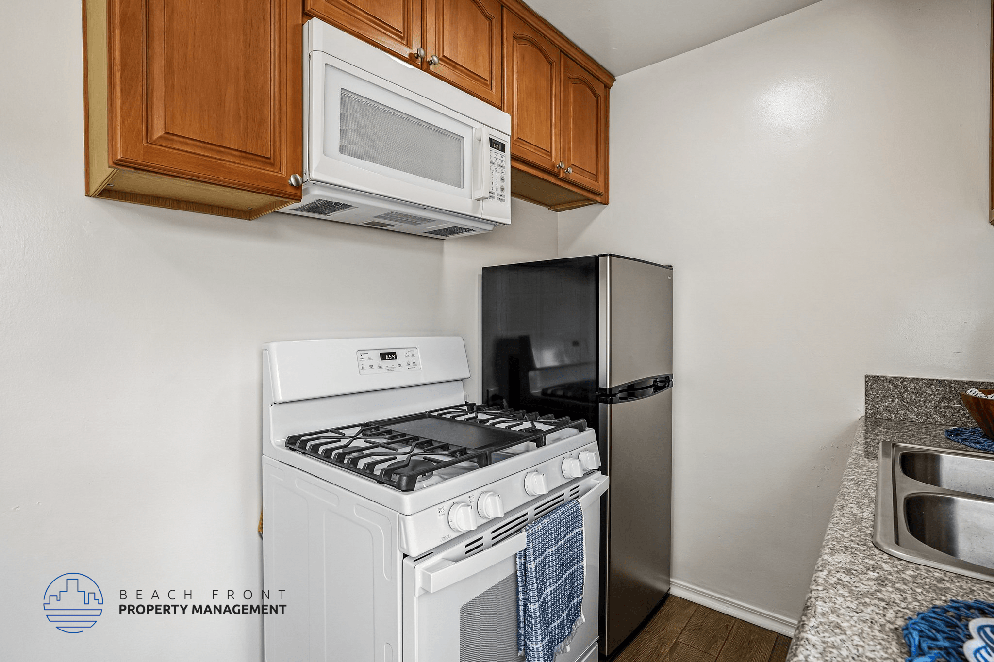 A kitchen with a white stove top oven and a black refrigerator.